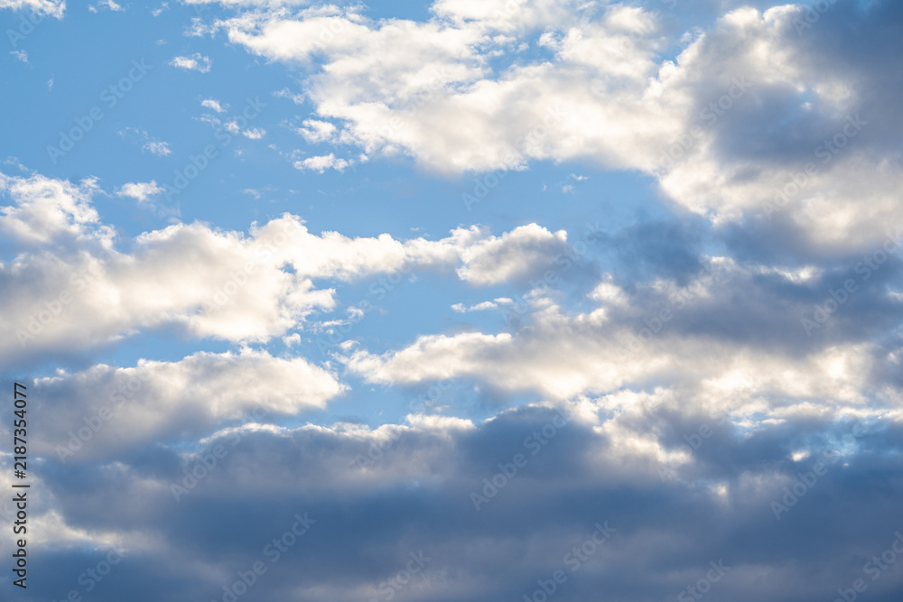 Fototapeta premium Fluffy white clouds in a bright blue sky cumulus clouds sun light