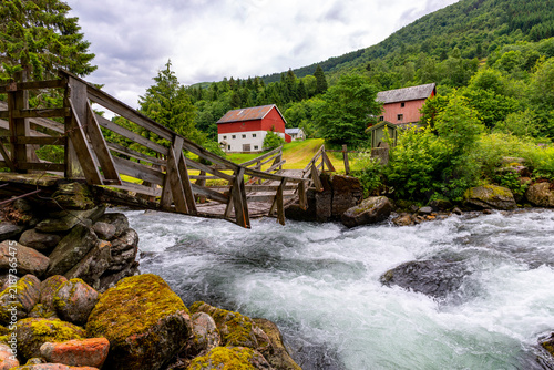 A beautiful wooden bridge over a mountain river. A seasonal scenery of Eidsdal village in World Heritage area of Western Norway.
