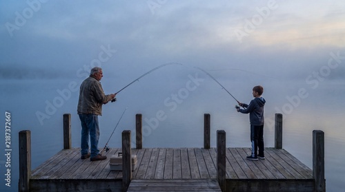 Grandfather and Grandson Casting Fishing Lines from a Dock