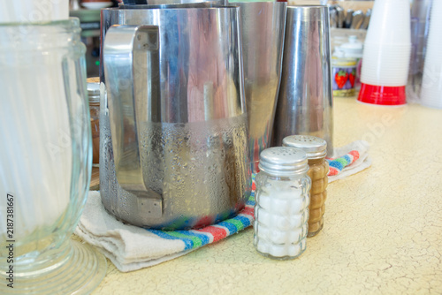 Coffee shop counter with metal pitchers and salt shakers