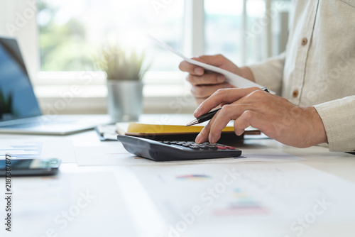 Cuadro en lienzo Deduction planning, debt asian accountant hand using calculator to calculating money balance from bill and income, cost budget expenses for pay money form personal individual on table at home