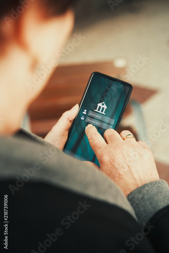 Bank account displaying on smartphone screen. Mature woman use smartphone for online accounting.