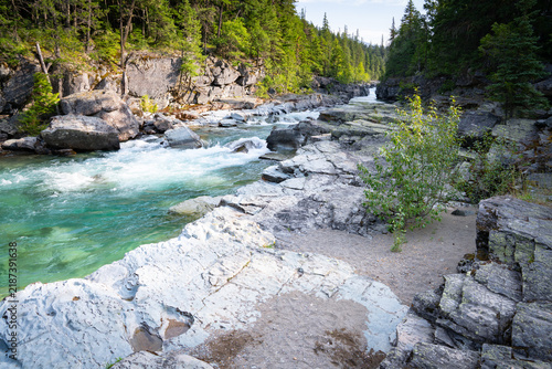 Clear turquoise water flows over smooth gray rocks