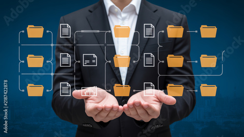 Business hand interacting with virtual screen showing KPI key performance indicators strategy and business icons on dark background.