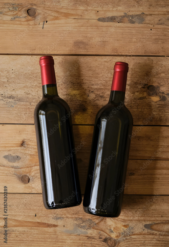 Obraz premium Wine culture and hospitality two red wine bottles on rustic wooden table for celebration dinner party winery marketing and beverage industry