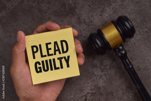 Cuadro en lienzo Hand holding a note labeled plead guilty beside a judge's gavel, symbolizing criminal charges, court proceedings, legal responsibility, and admission of guilt