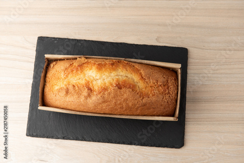 Freshly baked homemade yogurt sponge cake in paper mold on slate