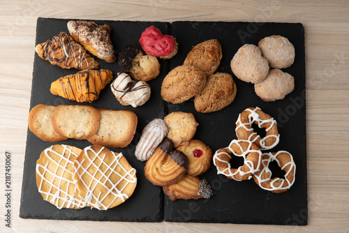 Assorted fine pastry selection and cookies on black slate boards