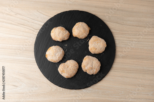 Artisanal sugar pastries on round slate tray