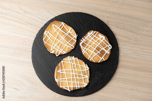 Traditional iced biscuits on round black slate plate