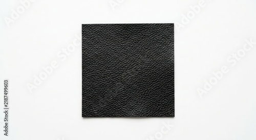 Square black textured leather material sample.