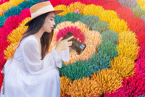 Foto A young Vietnamese woman in a white outfit is taking photos of colorful incense sticks in Hue, Vietnam