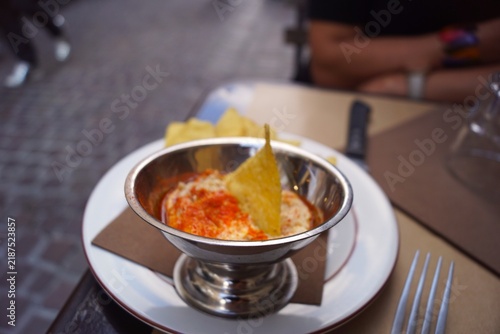 Obraz na plátně Hummus dip served with crispy tortilla chips in a restaurant