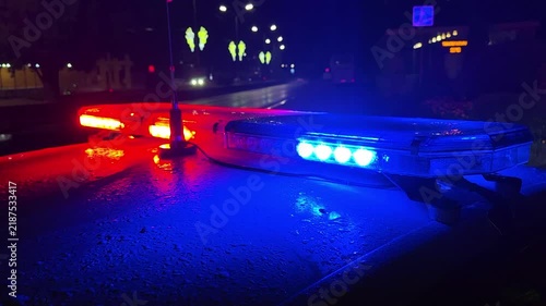 Police lights flashing at night downtown at crime scene, close up.