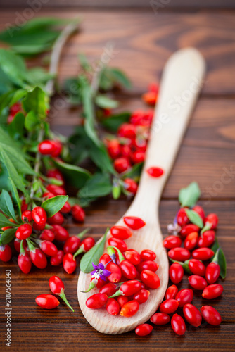 Bild auf Leinwand Ripe goji berries in ceramic bowl against rustic wood background