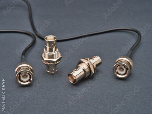 Foto BNC Connectors and Coaxial Cable - Close-up studio shot of BNC connectors and coaxial cable on a dark grey background, essential components for video and data transmission