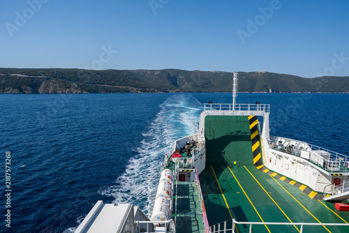 A ferry in the Adriatic Sea at a picturesque coastal port between the islands of Krk and Cres; blue water, the island coastline, summer travel and tourism in Croatia.