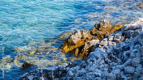 Bild auf Leinwand The rocky Mediterranean coast of the island of Cres, featuring blue sea waves, dramatic cliffs, a natural stony shore, and a summer seaside landscape