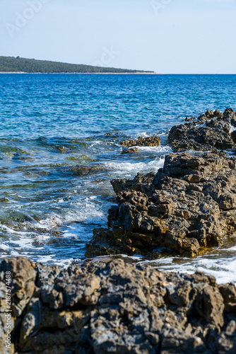 Obraz na plátně The rocky Mediterranean coast of the island of Cres, featuring blue sea waves, dramatic cliffs, a natural stony shore, and a summer seaside landscape