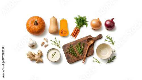Top view pumpkin soup ingredients, wooden cutting board, carrots, onion, garlic, herbs, bowls, spices, spices, flat lay composition, autumn cooking, copy space, food photography Thanksgiving