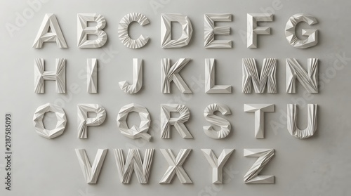 A full alphabet set of three dimensional block letters carefully arranged in sequential order on a simple neutral gray backdrop for various design projects and