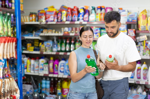 Foto Couple examines product dishwashing detergent while purchase in store