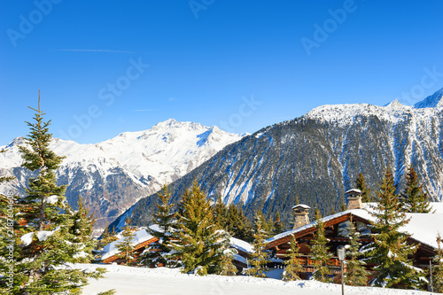 Vew of Courchevel village in winter Alps mountains, France. Snow-covered mountains and the blue sky at sunny day.
