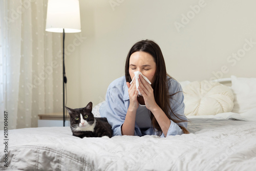 Cuadro en lienzo Adult woman experiencing sneezing and allergy symptoms near a domestic cat, repr