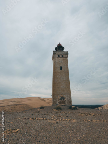 Obraz na plátně Rubjerg Knude Lighthouse standing in shifting sand dunes under dark stormy sky,