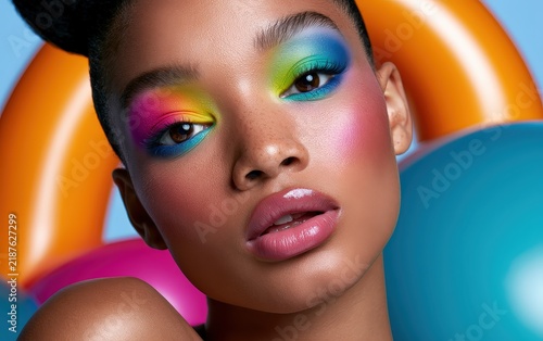 Stylish Woman with Colorful Makeup and Neon Outfit Posing with Balloons