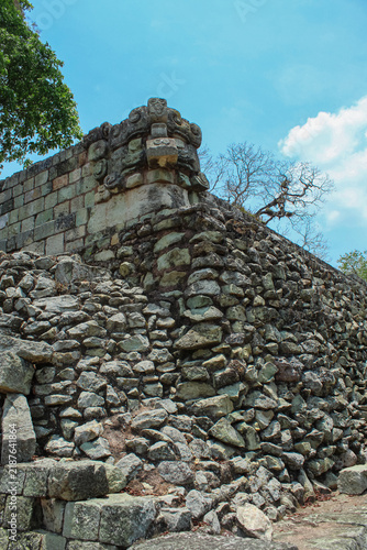 Quadro su tela Full view the inclined stone wall and Mayan mask carving at Copan Ruins
