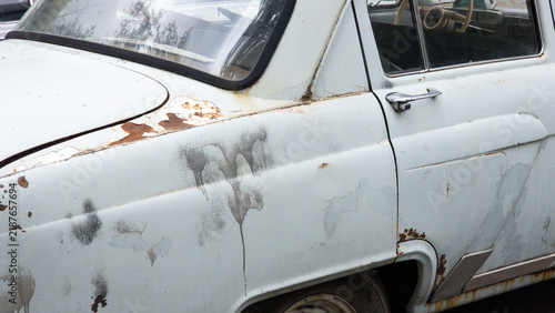 Old vintage automobile with rusty body panels and faded paint, showing corrosion, vehicle aging, classic car history and restoration concepts