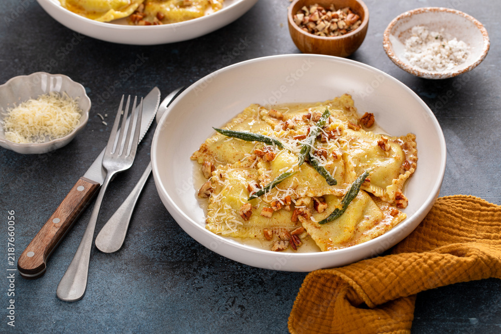 Obraz premium Pumpkin ravioli with brown butter and sage sauce served in bowls