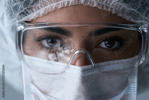 Female doctor wearing protective glasses and face mask in medical setting