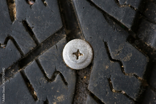 A metal self-tapping screw that has pierced a car tire.