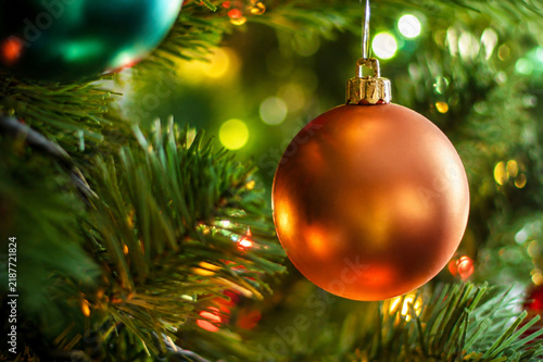 Golden Christmas Ball Ornament on Festive Evergreen Tree with Bokeh Lights