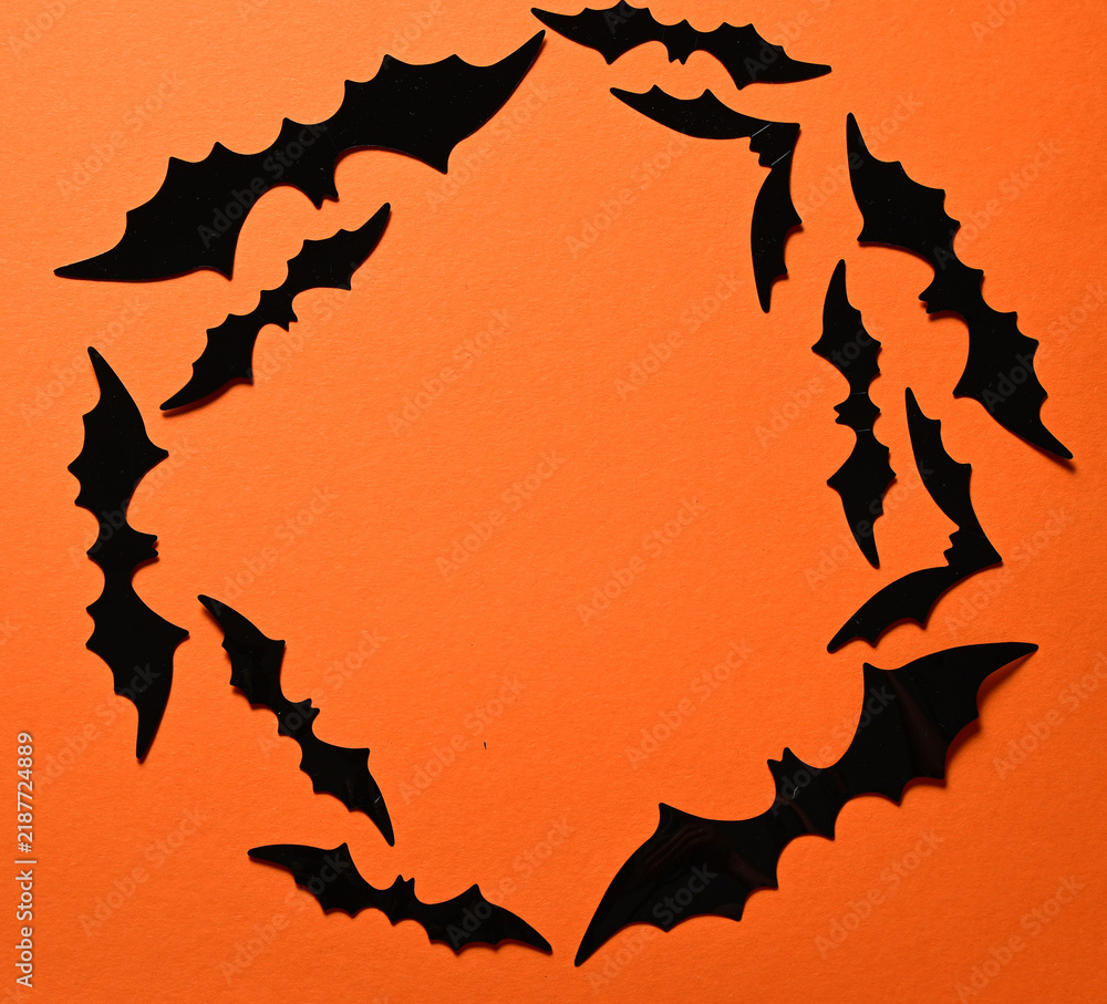 Fototapeta premium halloween decoration with black paper bats arranged in a circle on orange background