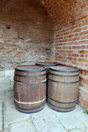 Three wooden barrels in a weathered brick vaulted alcove