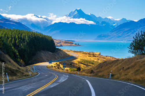 Obraz na plátně Empty highway curving beside turquoise Lake Pukaki toward Aoraki Mount Cook, New