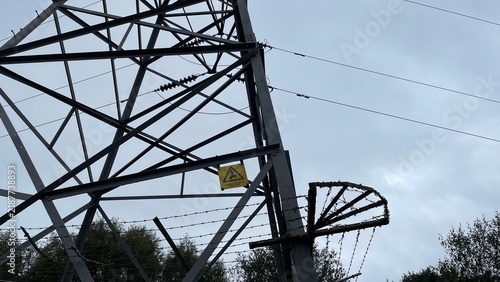 Fotografía Electricity Pylon Base with Danger of Death Warning Sign and Barbed Wire Fence