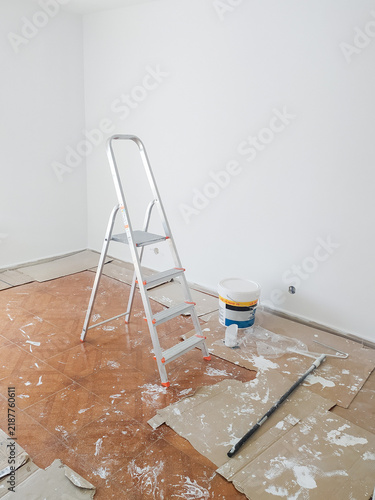 Fotografía A metal stepladder and paint bucket stand in an empty room during a home renovation