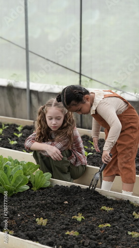 Two girls learning about gardening and growing vegetables.