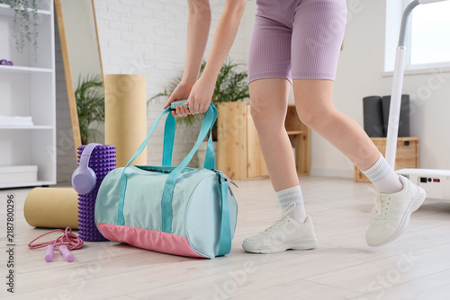 Healthy lifestyle and fitness routine, woman picking up gym bag with workout ...
