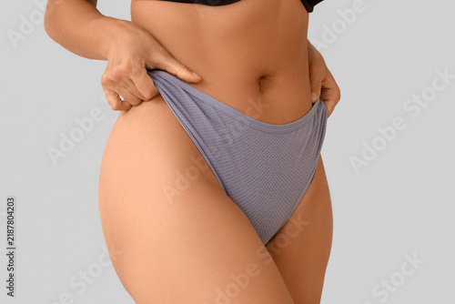 Принти на полотні Young woman in menstrual panties on light background, closeup
