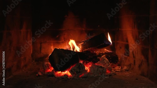 Burning Real Fireplace. Glowing Embers Create a Serene Ambiance. Warm Flames Dance on Burning Logs, Creating a Cozy and Inviting Atmosphere. The Flickering Light and Gentle Heat Provide Relaxation and
