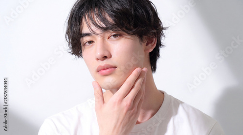 Tapety artystyczne あごに手を当てて見つめる若い日本人男性
