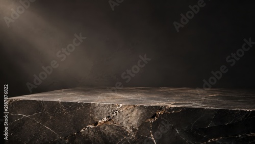 Textured dark marble display surface with dramatic lighting