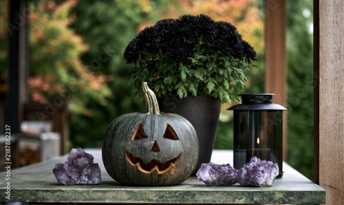 Pumpkin with carved face surrounded by crystals and lantern