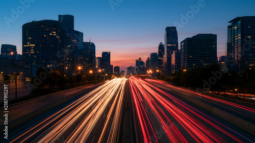 Dynamic long exposure photograph of car light trails on a busy city highway at dusk.