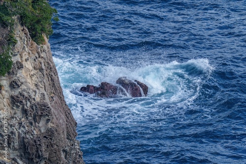 Fotografie 岩礁に打ち寄せる激しい白波と断崖絶壁の海岸風景